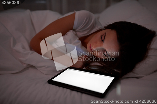 Image of woman with tablet pc sleeping in bed at night