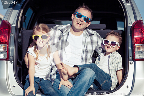 Image of Happy family getting ready for road trip on a sunny day