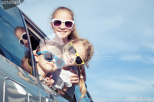 Image of Happy children getting ready for road trip on a sunny day