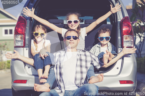 Image of Happy family getting ready for road trip on a sunny day