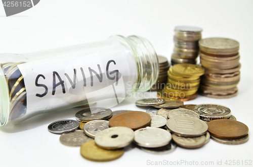 Image of Saving lable in a glass jar with coins spilling out