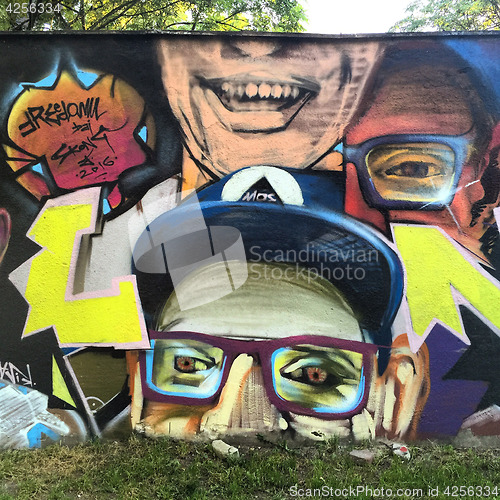 Image of WROCLAW, POLAND-AUGUST 30, 2016: Colorful graffiti in back alley of downtown, depicts human faces