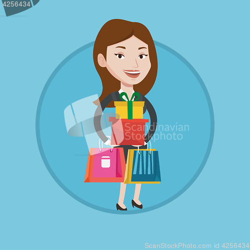 Image of Happy woman holding shopping bags and gift boxes.