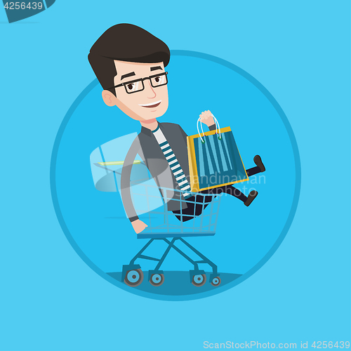 Image of Happy man riding by shopping trolley.