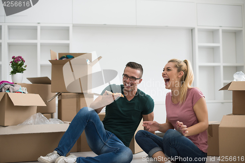 Image of young couple have a pizza lunch break on the floor