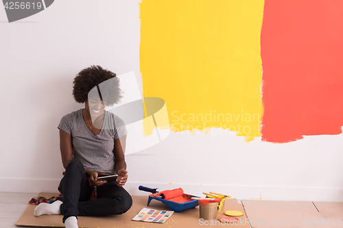 Image of back female painter sitting on floor