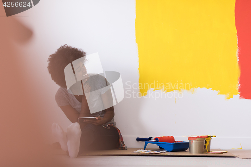 Image of back female painter sitting on floor