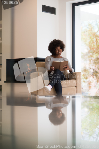 Image of black woman at home reading book