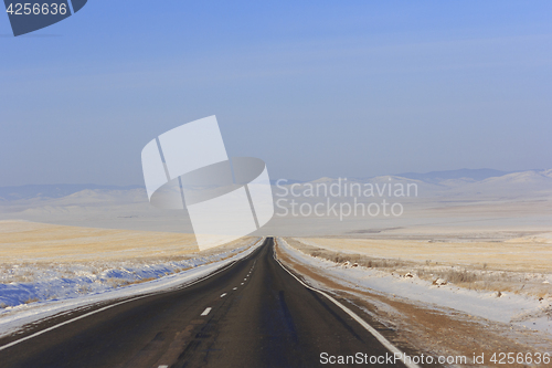 Image of Winter road leaving into distance into the mountains