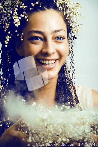 Image of young pretty brunette girl with bouquet of little white spring f