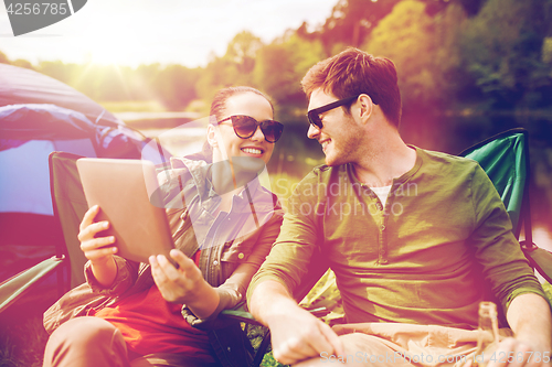 Image of happy couple with tablet pc at camping tent