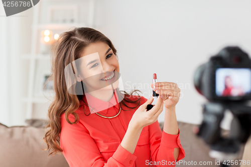 Image of woman with lipstick and camera recording video