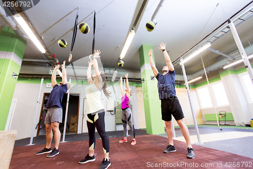 Image of group of people with medicine ball training in gym