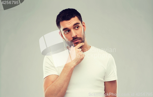 Image of man thinking over gray background