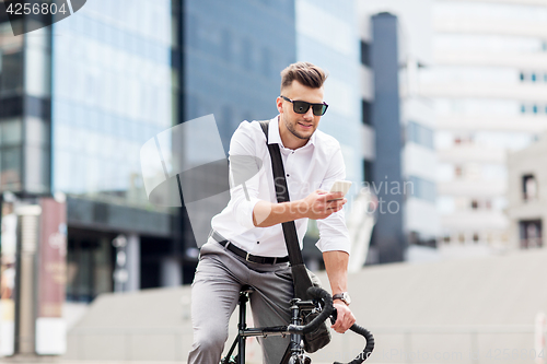 Image of man with bicycle and smartphone on city street