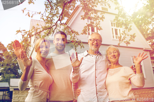 Image of happy family in front of house outdoors