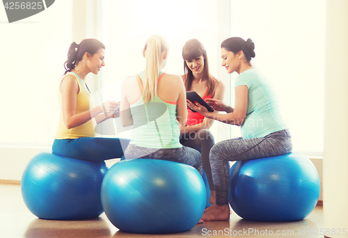 Image of happy pregnant women with gadgets in gym