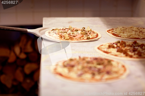 Image of peel taking pizza off table at pizzeria