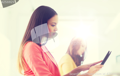 Image of creative african woman with tablet pc at office