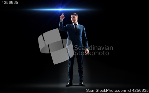 Image of businessman in suit pointing finger to laser light