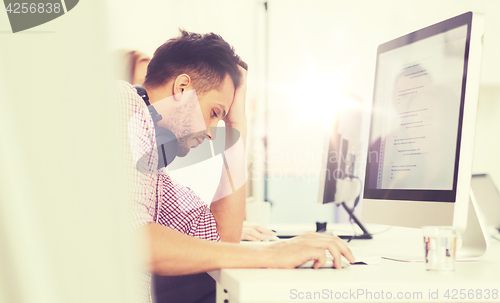 Image of stressed software developer at office