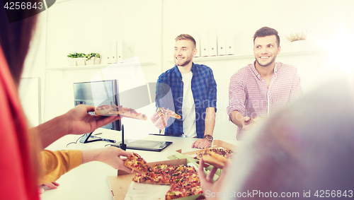 Image of happy business team eating pizza in office