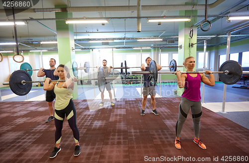 Image of group of people training with barbells in gym