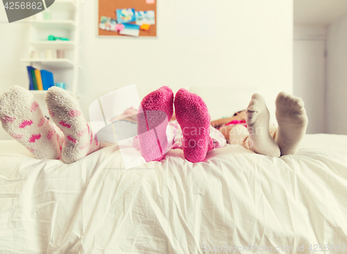 Image of close up of women feet in socks on bed at home