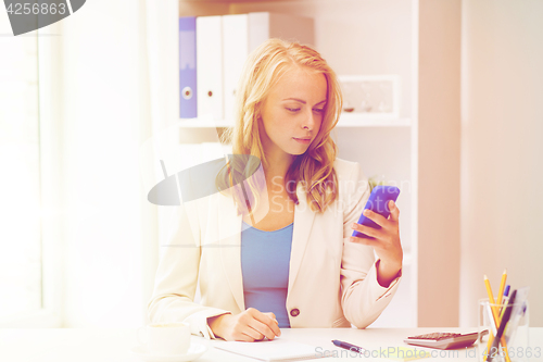 Image of businesswoman texting on smartphone at office