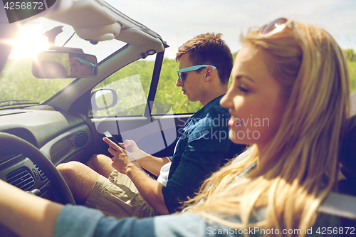 Image of man texting on smartphone driving in cabriolet car