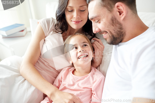Image of happy family in bed at home