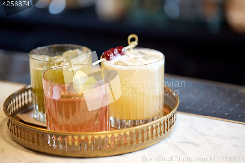 Image of tray with glasses of cocktails at bar