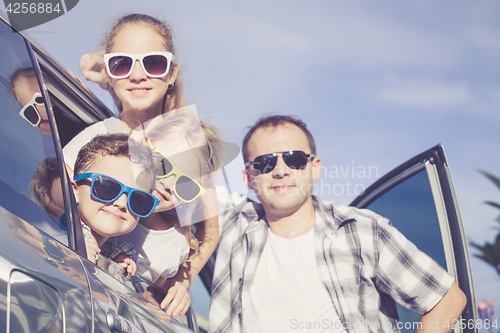 Image of Happy family getting ready for road trip on a sunny day