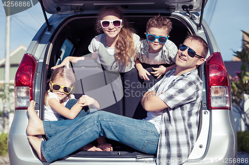 Image of Happy family getting ready for road trip on a sunny day