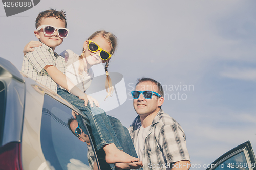 Image of Happy family getting ready for road trip on a sunny day
