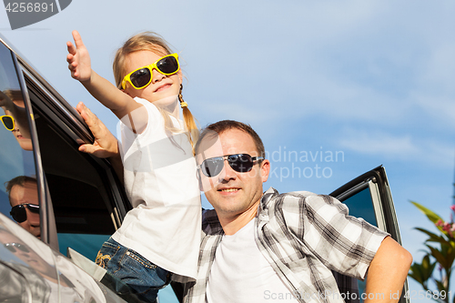 Image of Happy father and daughter getting ready for road trip on a sunny