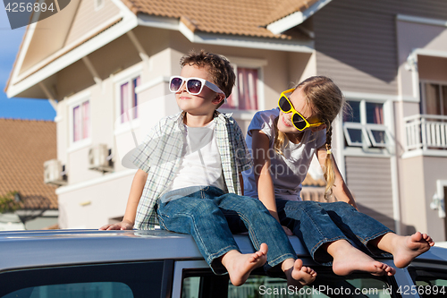 Image of Happy children getting ready for road trip on a sunny day.