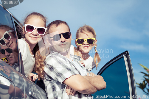 Image of Happy family getting ready for road trip on a sunny day