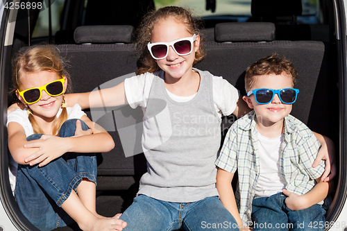 Image of Happy children getting ready for road trip on a sunny day. 