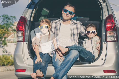 Image of Happy family getting ready for road trip on a sunny day