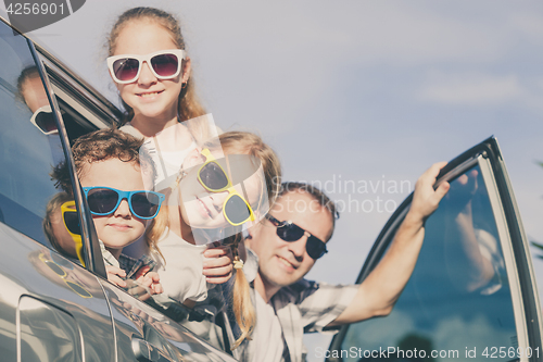 Image of Happy family getting ready for road trip on a sunny day