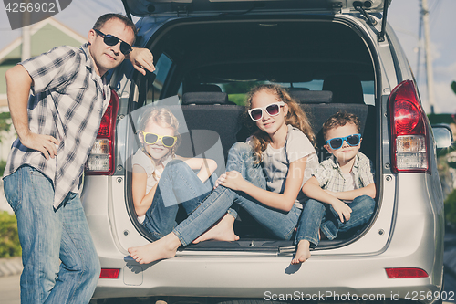 Image of Happy family getting ready for road trip on a sunny day