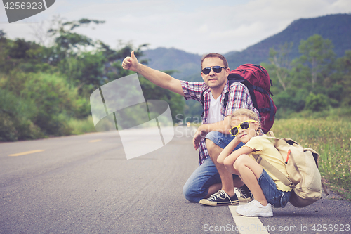 Image of Father and daughter walking on the road.