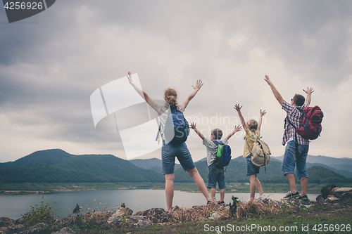 Image of Happy family standing near the lake.