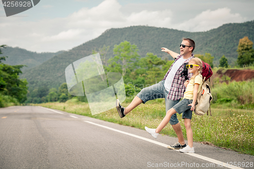 Image of Father and daughter walking on the road.