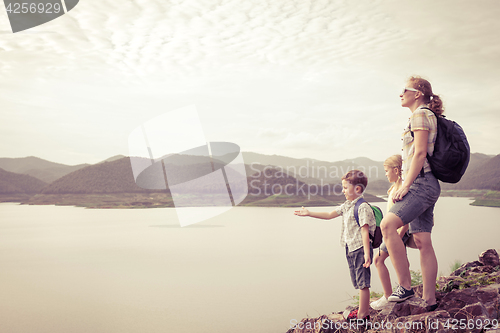 Image of Happy family standing near the lake.