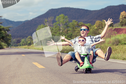 Image of Father and son playing on the road.