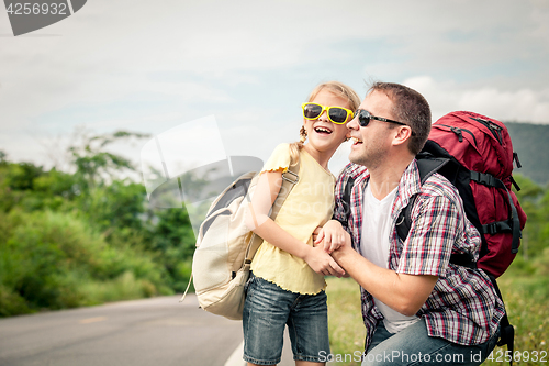 Image of Father and daughter walking on the road.