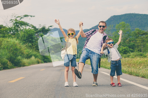 Image of Father and children walking on the road.