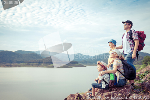 Image of Happy family standing near the lake.